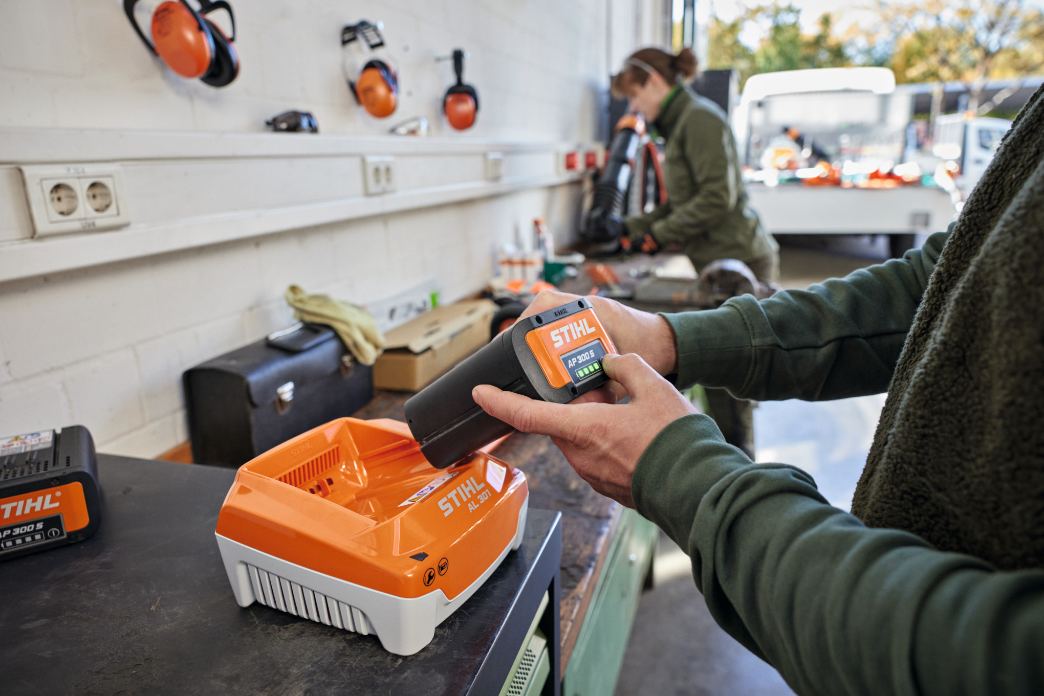 Una persona introduce una batería STIHL AP 300 S en un cargador rápido STIHL AL 301