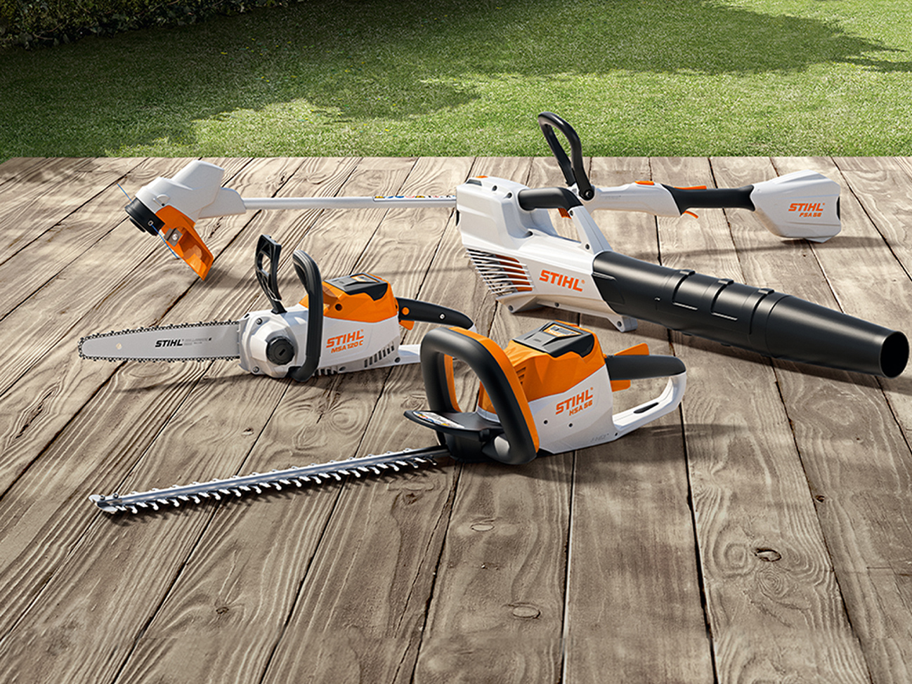 Motosierra a batería STIHL MSA 120 C, desmalezadora a batería FSA 57, cortasetos a batería HSA 56, soplador a batería BGA 56 en terraza de madera